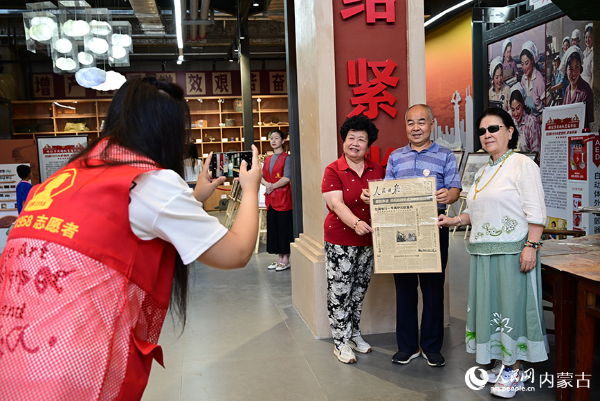 游客在“包棉1958”和旧报纸打卡拍照。人民网记者 寇雅楠摄