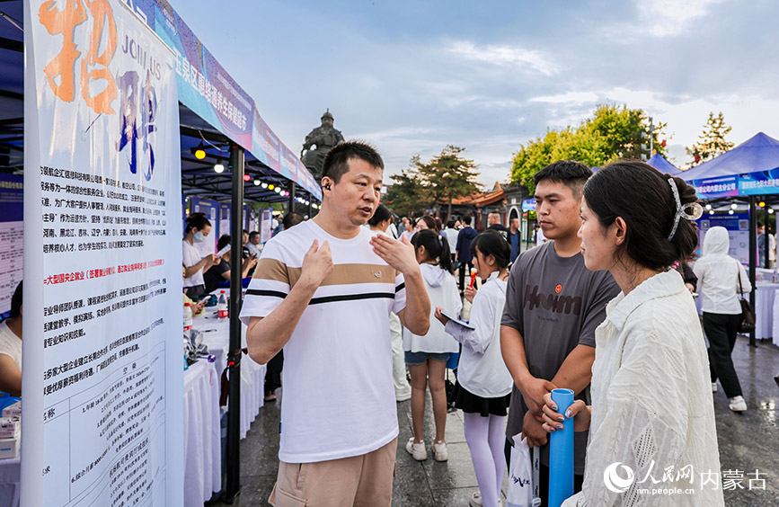 6月28日晚，招聘人員在呼和浩特市玉泉區“人才夜市”專場招聘會現場向求職者介紹崗位信息。丁根厚攝