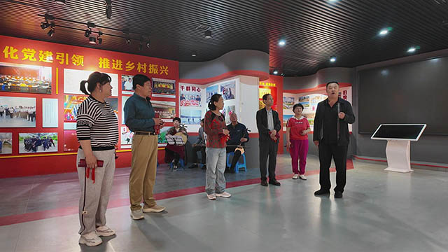 刘占林在村史馆向来客分享西山根村奋斗故事