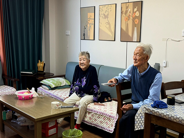 包文龙夫妇在康养中心宿舍里休闲的看电视。 宋丹丹摄