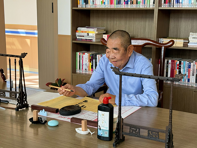 康養中心活動室裡，老年朋友在寫書法。 宋丹丹攝