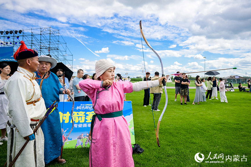 7月5日，游客在呼和浩特城市那達慕活動現場觀看射箭比賽。丁根厚攝