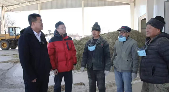 薛志龍（左一）在村裡的檸條飼料加工廠了解情況。資料圖