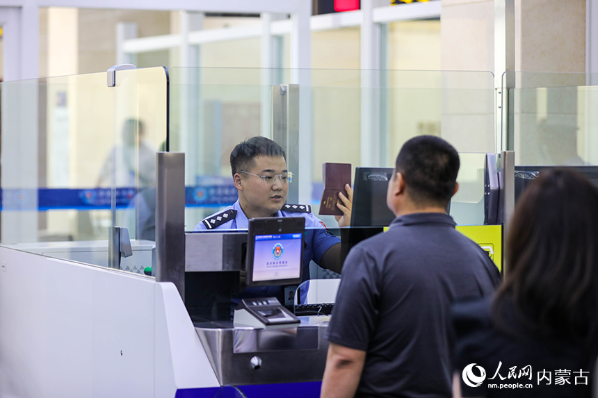 二连出入境边防检查站移民管理警察为入境航班旅客办理通关手续。杨金烨摄