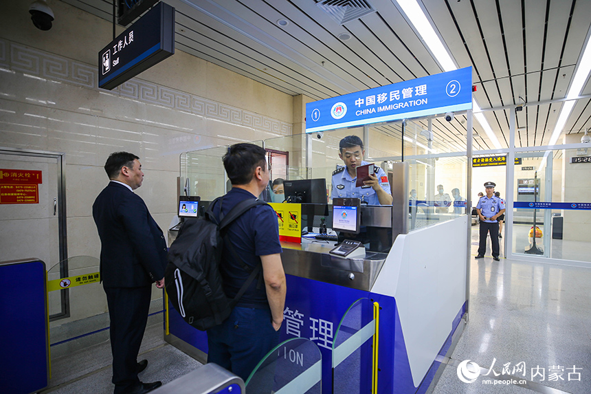 二连出入境边防检查站移民管理警察为入境航班旅客办理通关手续。杨金烨摄