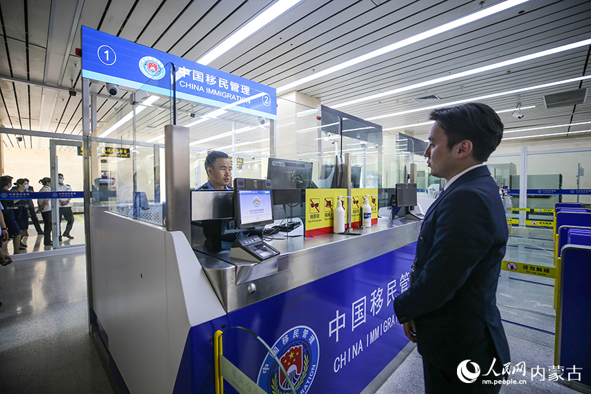 二连出入境边防检查站移民管理警察为入境航班旅客办理通关手续。杨金烨摄