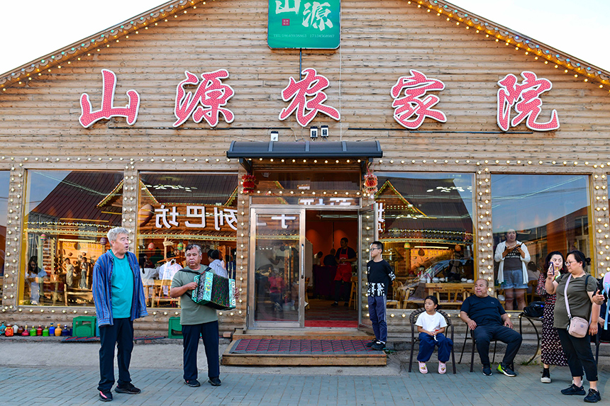 村民在額爾古納市恩和俄羅斯族民族鄉恩和村街頭為游客表演節目。王正攝