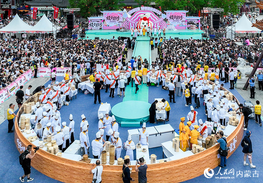 7月19日，游客在呼和浩特市玉泉区塞上老街旅游休闲街区参加烧卖美食季活动。丁根厚摄