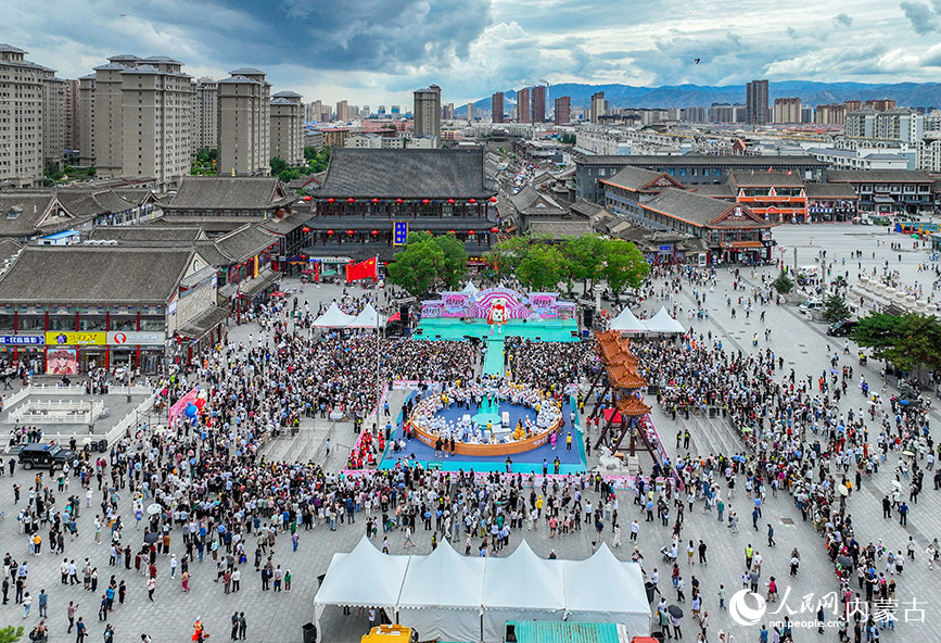 7月19日,游客在呼和浩特市玉泉区塞上老街旅游休闲街区参加烧卖美食季活动。丁根厚摄