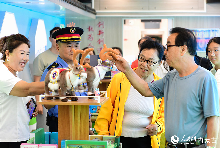 8月10日，游客在“阿爾山號”旅游專列上選購紀念品。王正攝