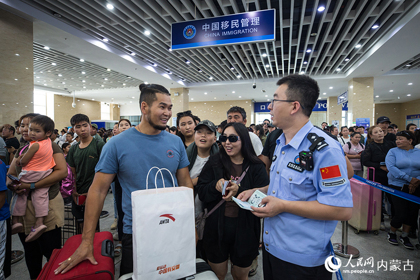 二连出入境边防检查站移民管理警察为旅客提供通关服务。郭鹏杰摄