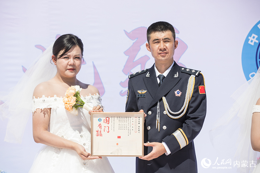 一对新人展示集体婚礼纪念证书。郭鹏杰摄