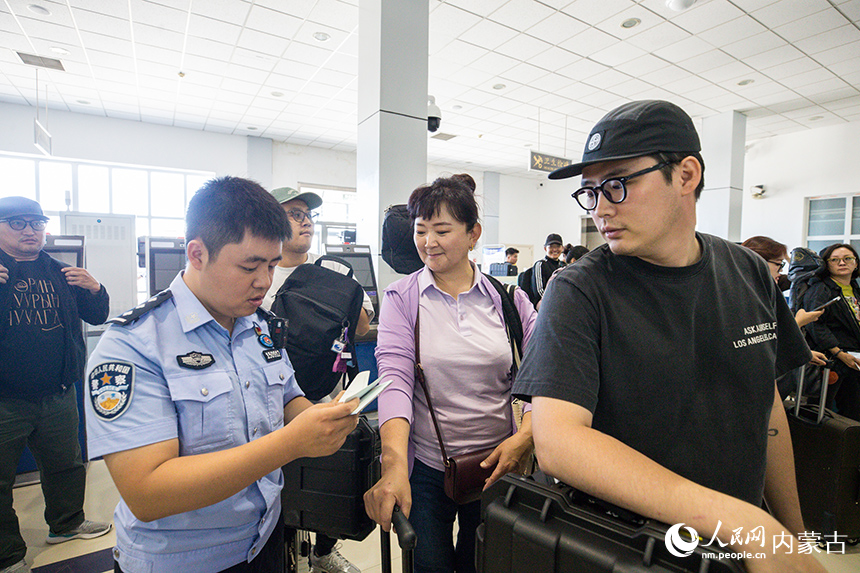 二连出入境边防检查站移民管理警察为参加中蒙博览会的客商办理入境通关手续。郭鹏杰摄