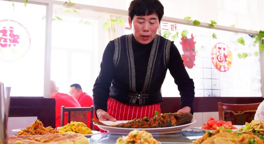 郝家窯村一家農家樂餐廳經營者正在為游客端上剛燉好的托縣鯉魚。王建宏攝