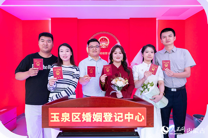 新人们在呼和浩特市玉泉区婚姻登记中心手持结婚证留影。丁根厚摄