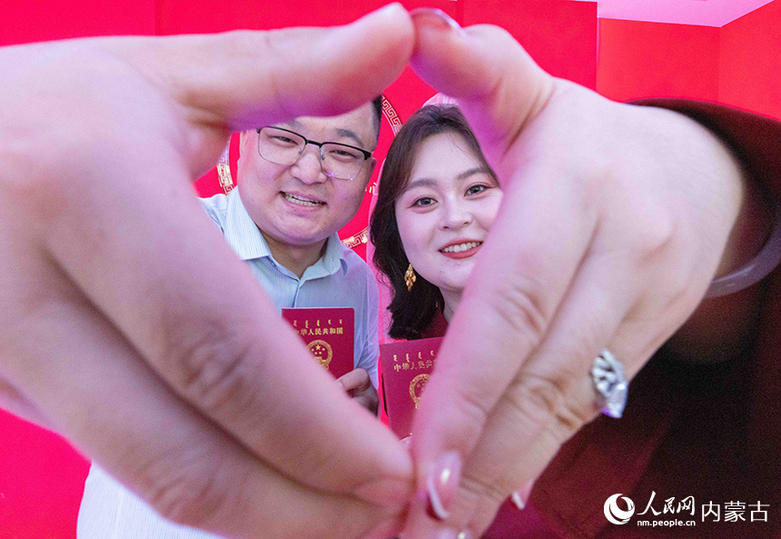 新人们在呼和浩特市玉泉区婚姻登记中心手持结婚证留影。丁根厚摄