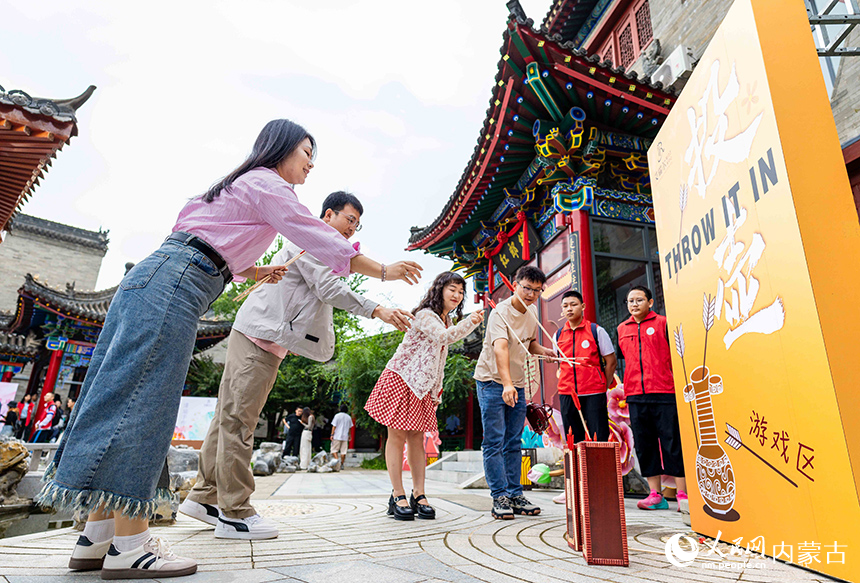 新人们在呼和浩特市玉泉区“我们的节日·七夕”主题活动现场体验祈福投壶项目，感受传统民俗文化魅力。丁根厚摄