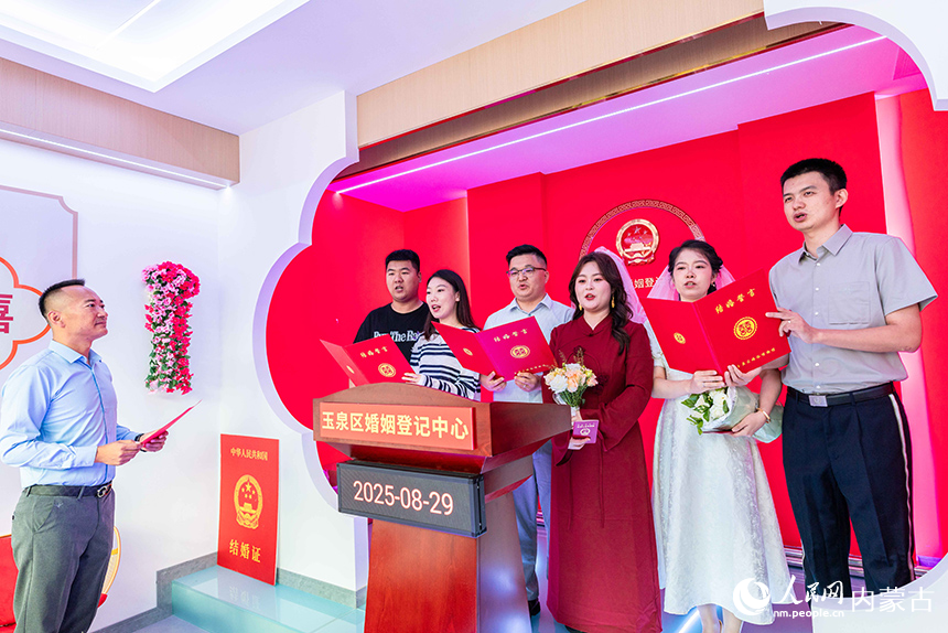 新人们在呼和浩特市玉泉区婚姻登记中心集体宣读《文明婚嫁移风易俗承诺书》。丁根厚摄