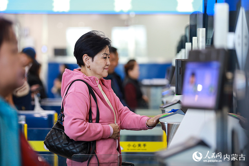 旅客在内蒙古二连浩特公路口岸联检大厅办理入境手续。郭鹏杰摄