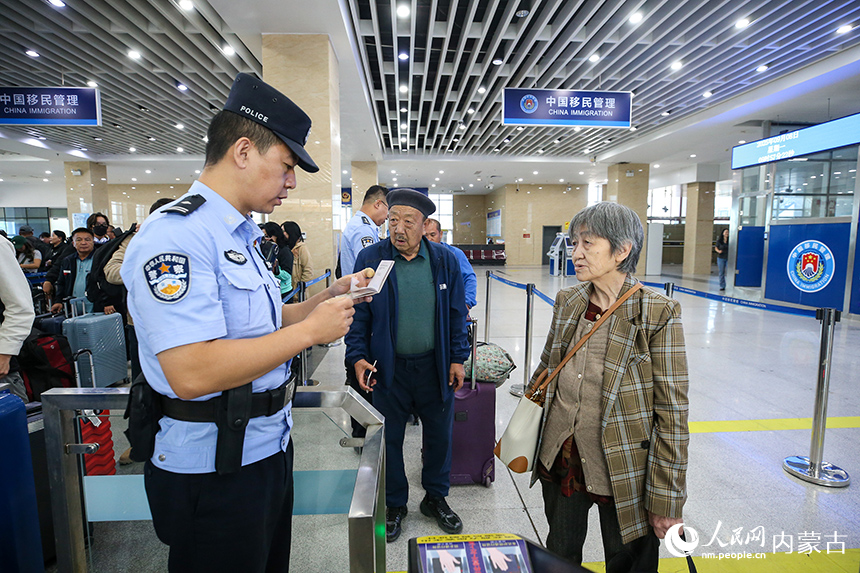 二连出入境边防检查站移民管理警察为老年旅客提供通关咨询。郭鹏杰摄