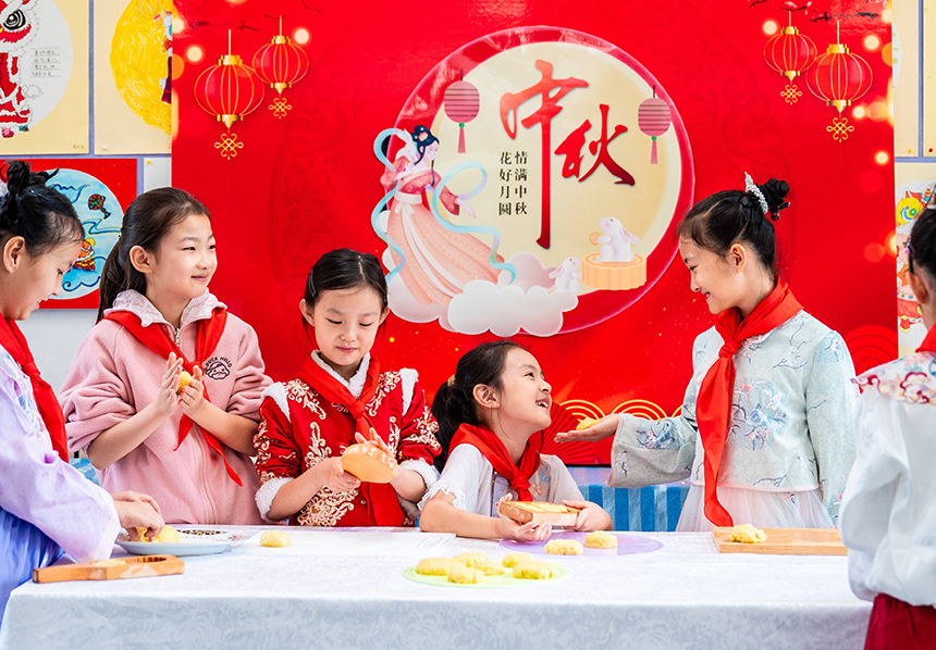 内蒙古呼和浩特市玉泉区清泉街小学学生在中秋节主题活动上学做月饼。丁根厚摄