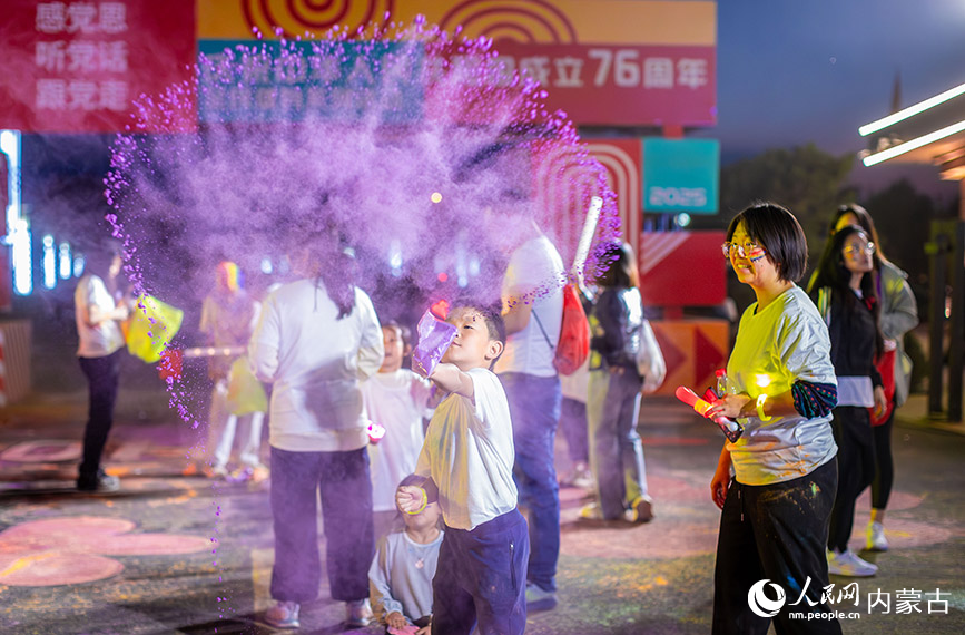 10月2日晚，呼和浩特市玉泉区清屿林夕房车营地，参加彩虹荧光跑活动的小朋友在现场挥洒彩粉嬉戏。丁根厚摄