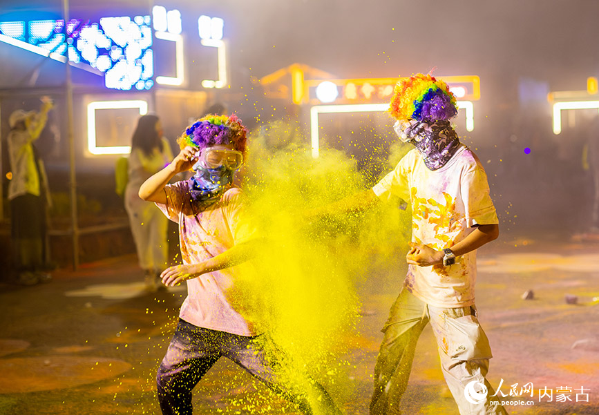 10月2日晚，呼和浩特市玉泉区清屿林夕房车营地，参加彩虹荧光跑活动的小朋友在现场互喷彩粉嬉戏。丁根厚摄