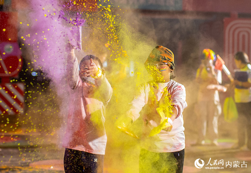 10月2日晚，呼和浩特市玉泉區清嶼林夕房車營地，參加彩虹熒光跑活動的小朋友在現場揮洒彩粉嬉戲。丁根厚攝