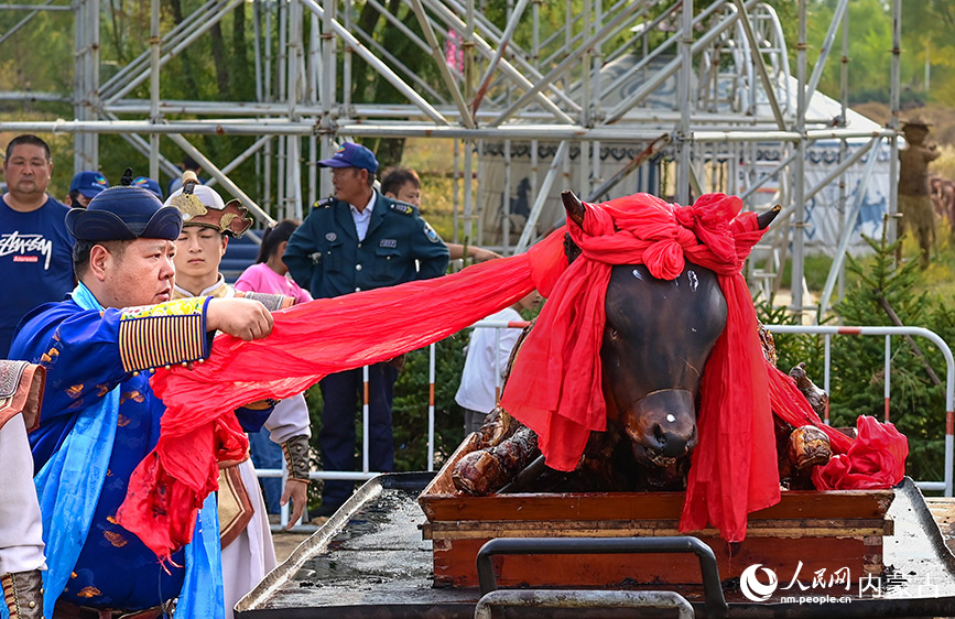 10月4日，民间艺人在鄂尔多斯市伊金霍洛旗鄂尔多斯文化产业园为烤全牛剪彩。王正摄