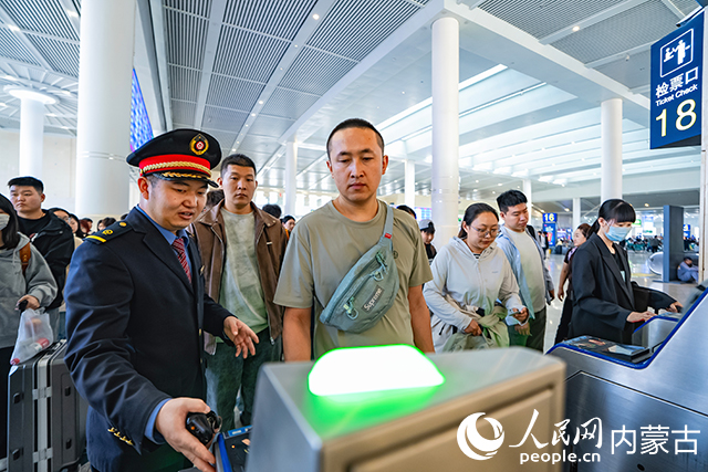 旅客在呼和浩特东站排队通过进站闸机。杨颐摄