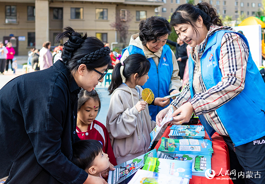 呼和浩特市玉泉區“文明市集”主題活動現場，科普志願者在向居民普及科學知識。丁根厚攝