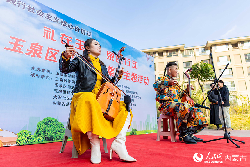 呼和浩特市玉泉区“文明市集”主题活动现场，乌兰牧骑队员在为社区居民表演马头琴演奏。丁根厚摄
