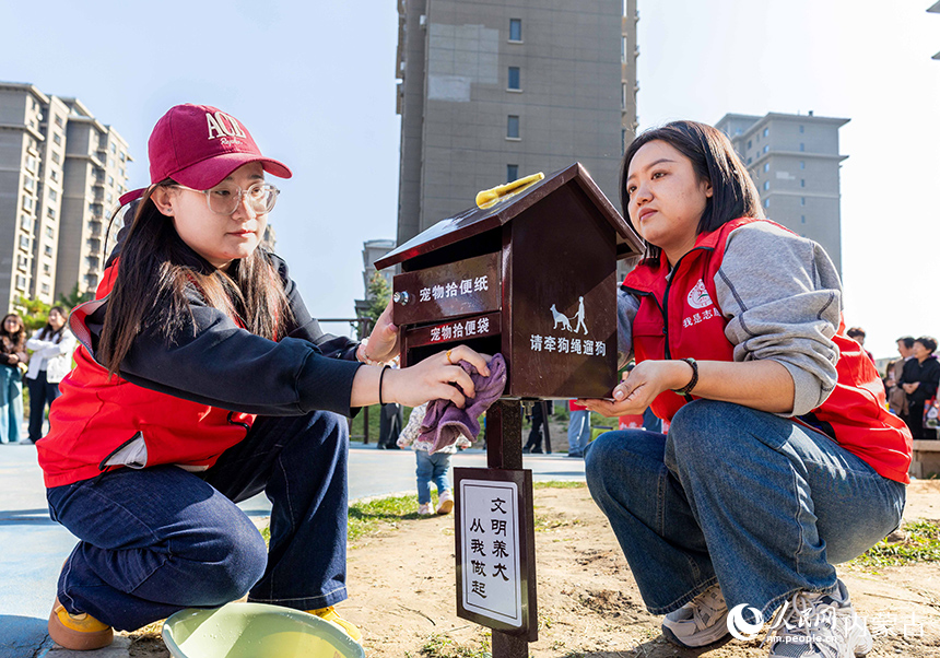 呼和浩特市玉泉區“文明市集”主題活動現場，志願者在擦拭“文明養犬”寵物便民箱。丁根厚攝