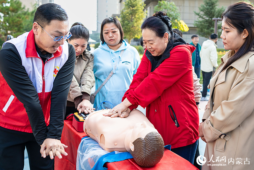 呼和浩特市玉泉區“文明市集”主題活動現場，社區居民在紅十字志願者指導下學習應急救護技能。丁根厚攝