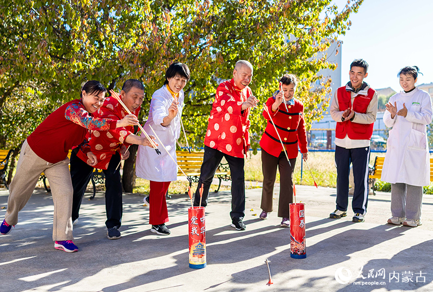 老人们在呼和浩特市玉泉区民政局“爱心敬老 情暖重阳”主题活动现场玩投壶游戏。丁根厚摄