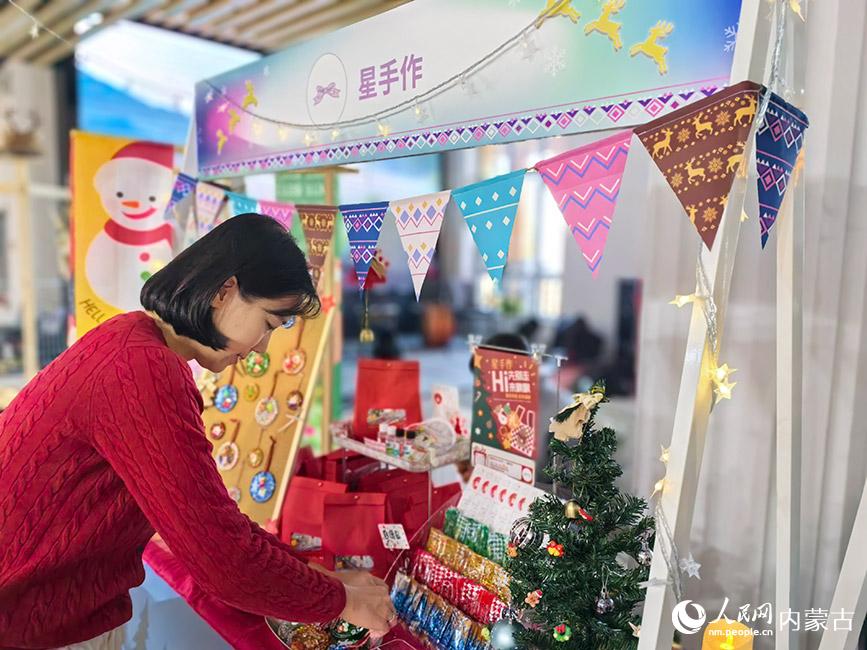 敖鲁古雅太阳城文创市集工作人员正在摊位前整理商品。人民网记者 富丽娟摄