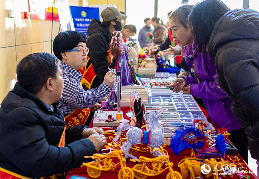 11月16日，呼和浩特市玉泉区残疾人职业技能竞赛现场，市民在残疾人就业成果展示区参观“敕勒川巧娘”手工艺品。丁根厚摄