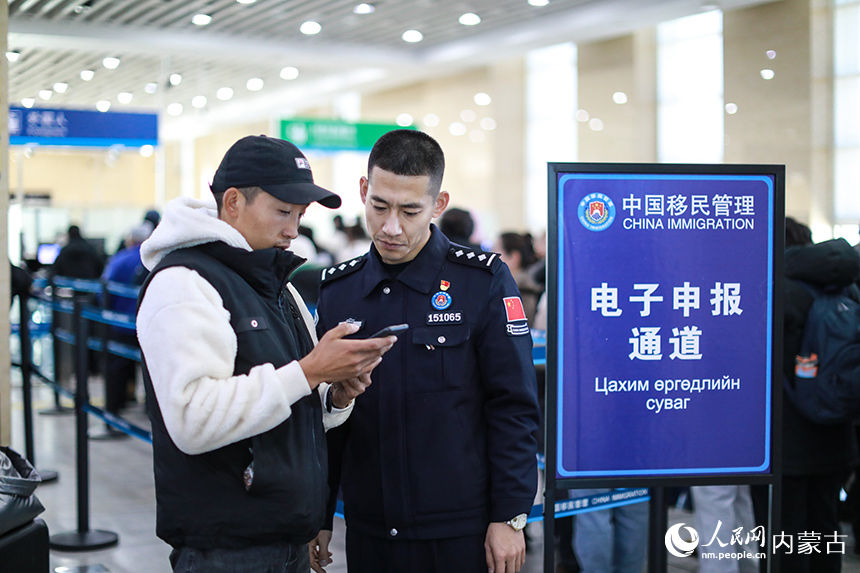 二连出入境边防检查站移民管理警察协助蒙古国旅客网上填报外国人入境卡。郭鹏杰摄