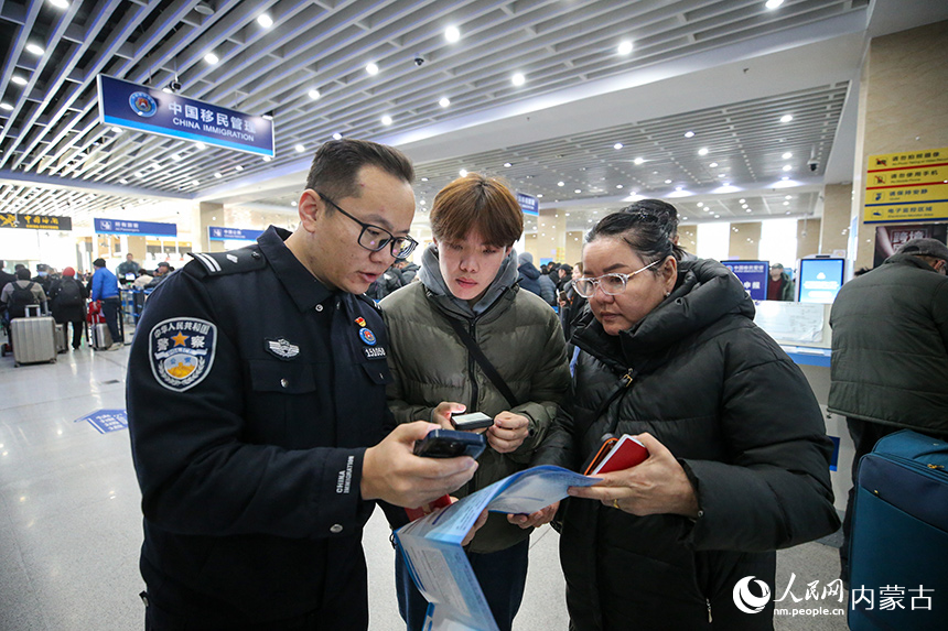 二连出入境边防检查站移民管理警察协助蒙古国旅客网上填报外国人入境卡。郭鹏杰摄