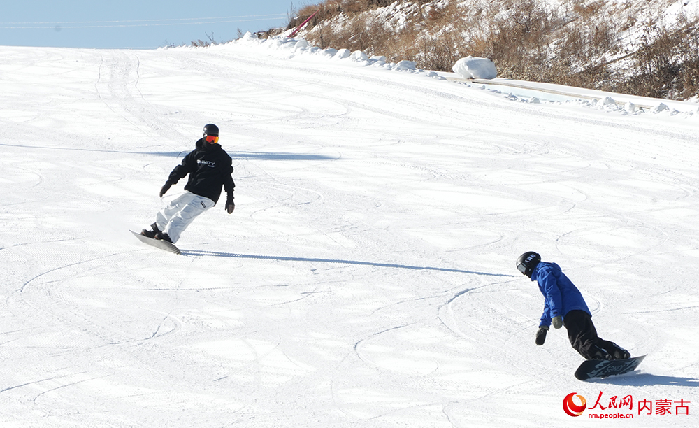 技術嫻熟的單板滑雪愛好者從賽道俯沖而下享受滑雪運動帶來的樂趣。人民網記者 張雪冬攝