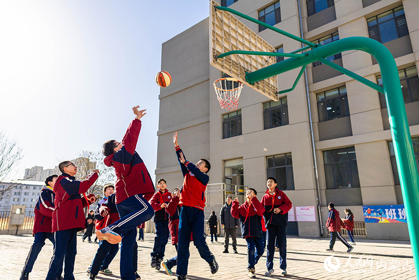 內蒙古呼和浩特市玉泉區石東路小學的學生在操場上打籃球。丁根攝