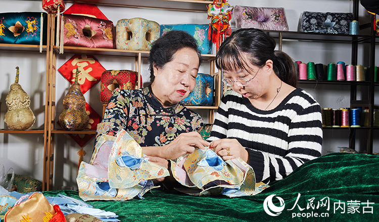 六合枕制作技艺传承人温永华教授徒弟如何缝制六合枕。人民网记者 张雪冬摄