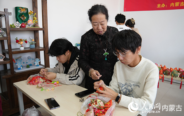 六合枕制作技艺传承人温永华指导学员学习。人民网记者 张雪冬摄