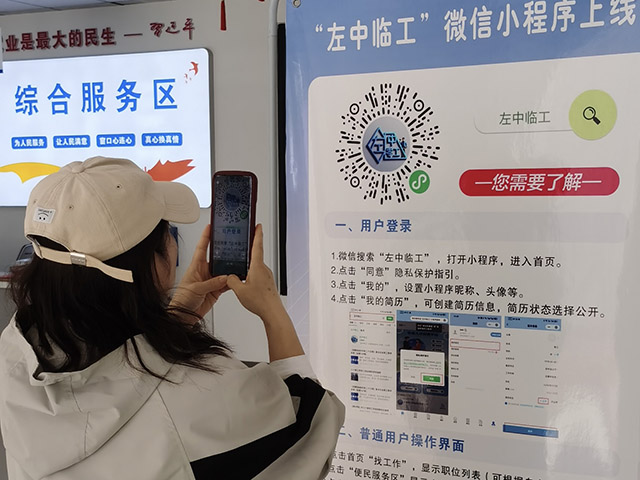 居民通过手机扫描“左中临工”小程序寻找工作岗位。王爱民摄