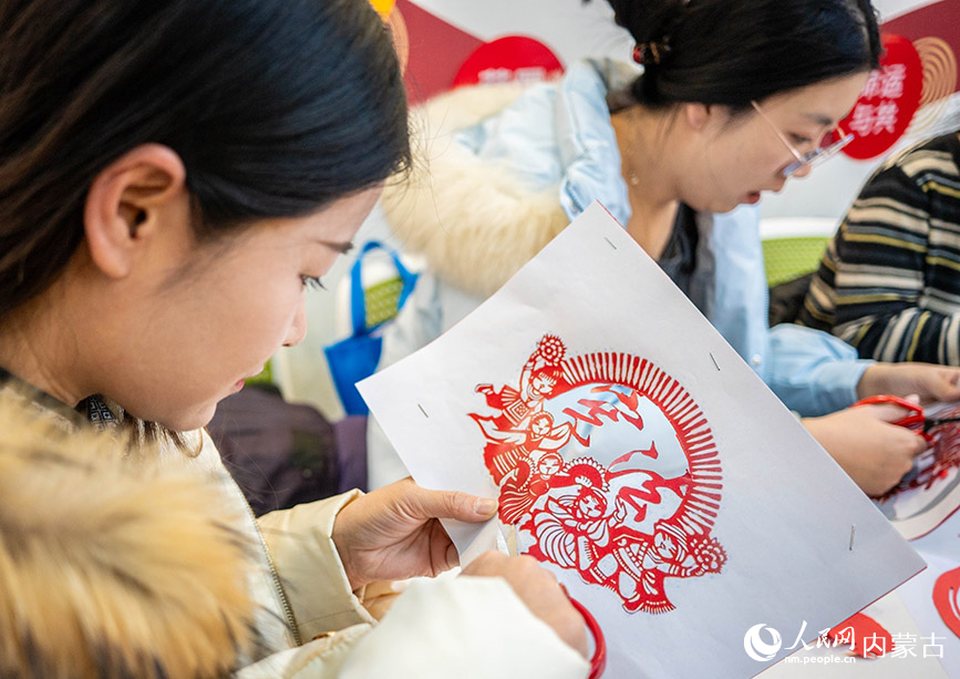 12月4日，呼和浩特市玉泉区清泉街社区的工作人员在“国家宪法日”主题活动上制作剪纸作品。丁根厚摄