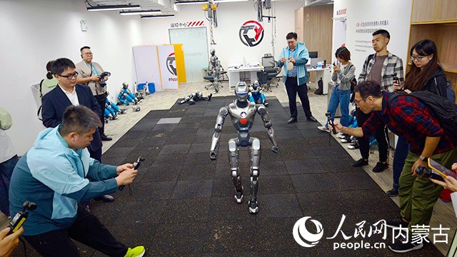 在深圳眾擎機器人公司,機器人現場演示格斗技巧,記者駐足記錄。人民網記者 張力洋攝