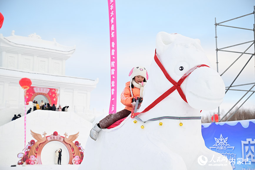 游客小朋友骑雪雕马。人民网记者 寇雅楠摄
