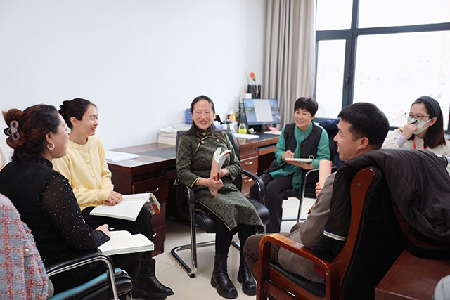圖為張潔手持書籍，與語文教研組教師圍坐開展教研活動。劉新平攝