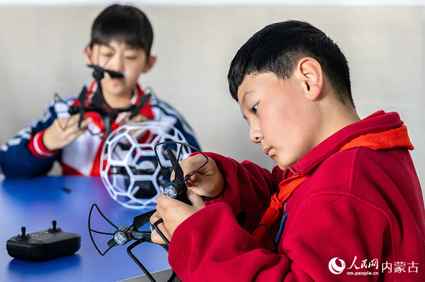 呼和浩特市玉泉區石東路小學無人機社團的學生在學習組裝無人機。丁根厚攝