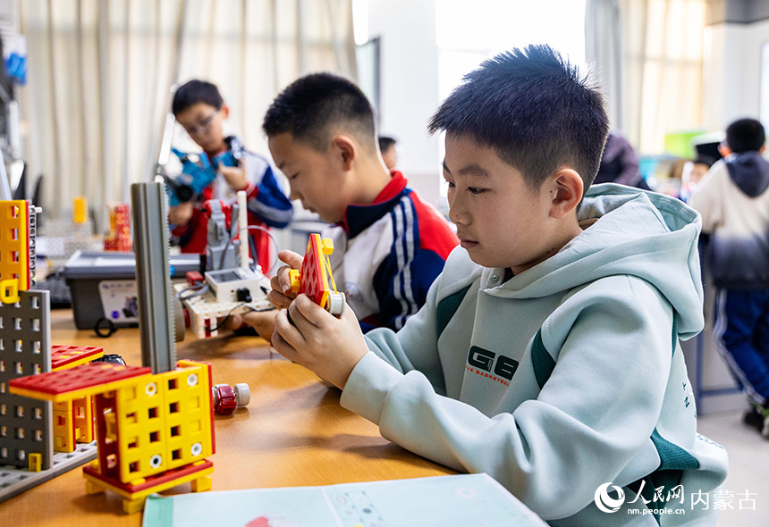 呼和浩特市玉泉區石東路小學機器人社團的學生在學習組裝機器人。丁根厚攝